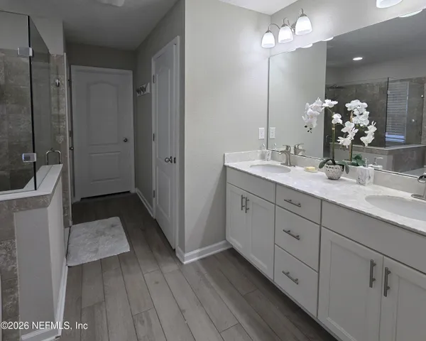 a bathroom with a bathtub a sink a window and a shower