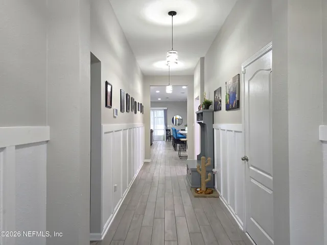 a view of a hallway with wooden floor and stairs