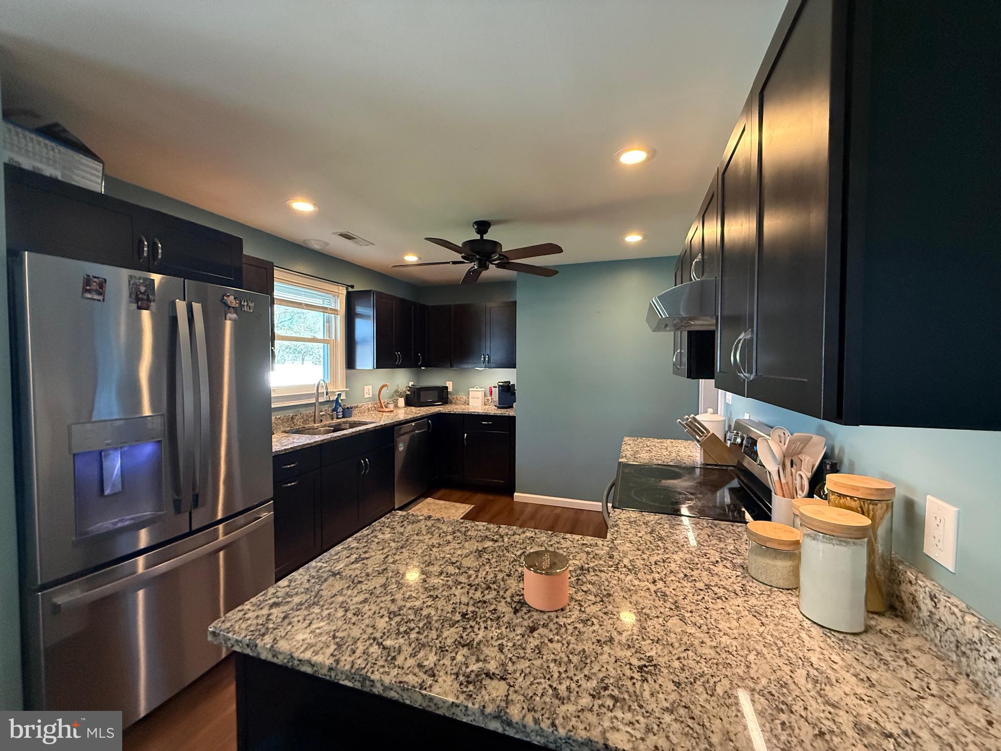 501 Chestnut Street Hebron, MD 21830 - Photo 13 of 30 a kitchen with stainless steel appliances kitchen island granite countertop a refrigerator and a sink