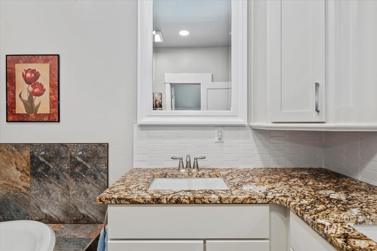 17322 Can-Ada Road Nampa, ID 83687 - Photo 17 of 44 Bathroom with vanity, tasteful backsplash, and a bathtub