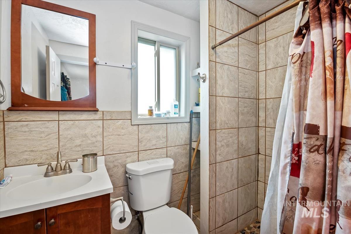 17322 Can-Ada Road Nampa, ID 83687 - Photo 22 of 44 Full bath featuring a stall shower, vanity, and tile walls
