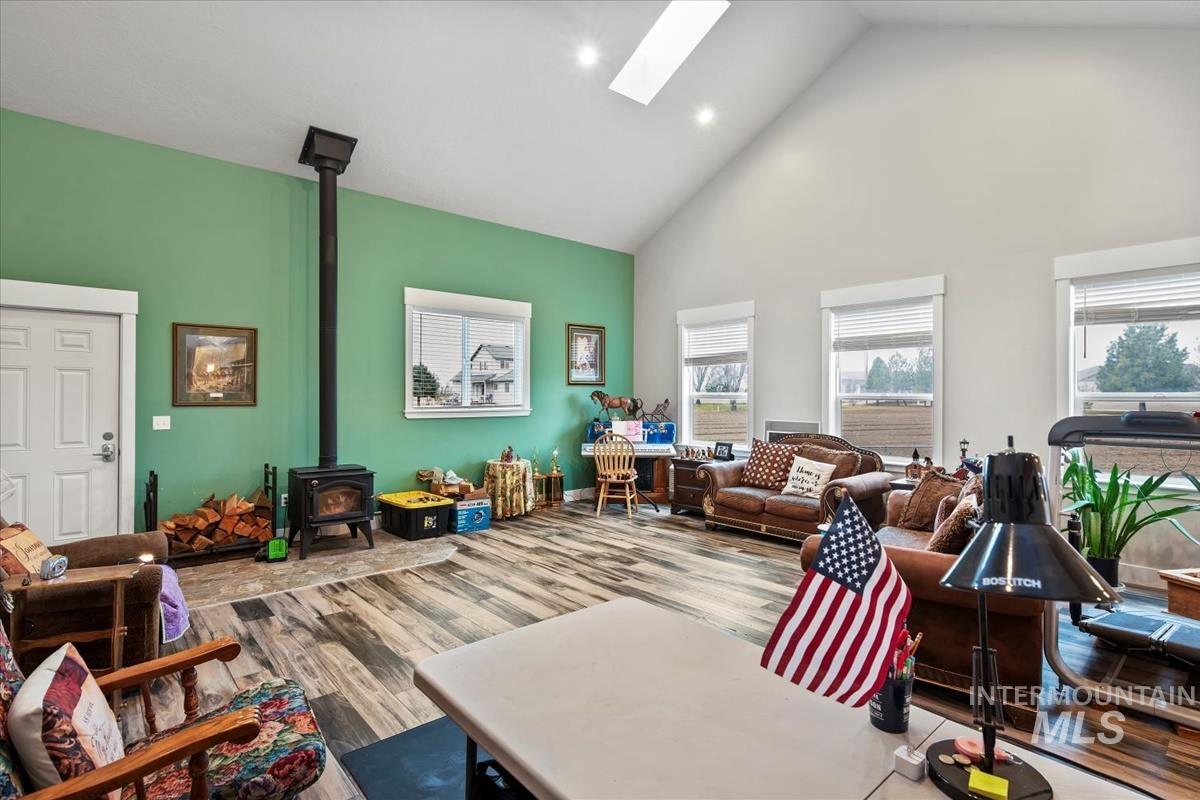 17322 Can-Ada Road Nampa, ID 83687 - Photo 24 of 44 Living area featuring a wood stove, wood finished floors, high vaulted ceiling, and a skylight