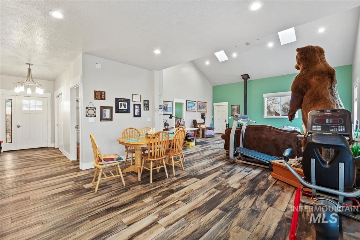 17322 Can-Ada Road Nampa, ID 83687 - Photo 3 of 44 Dining room featuring wood finished floors, a wood stove, recessed lighting, and high vaulted ceiling