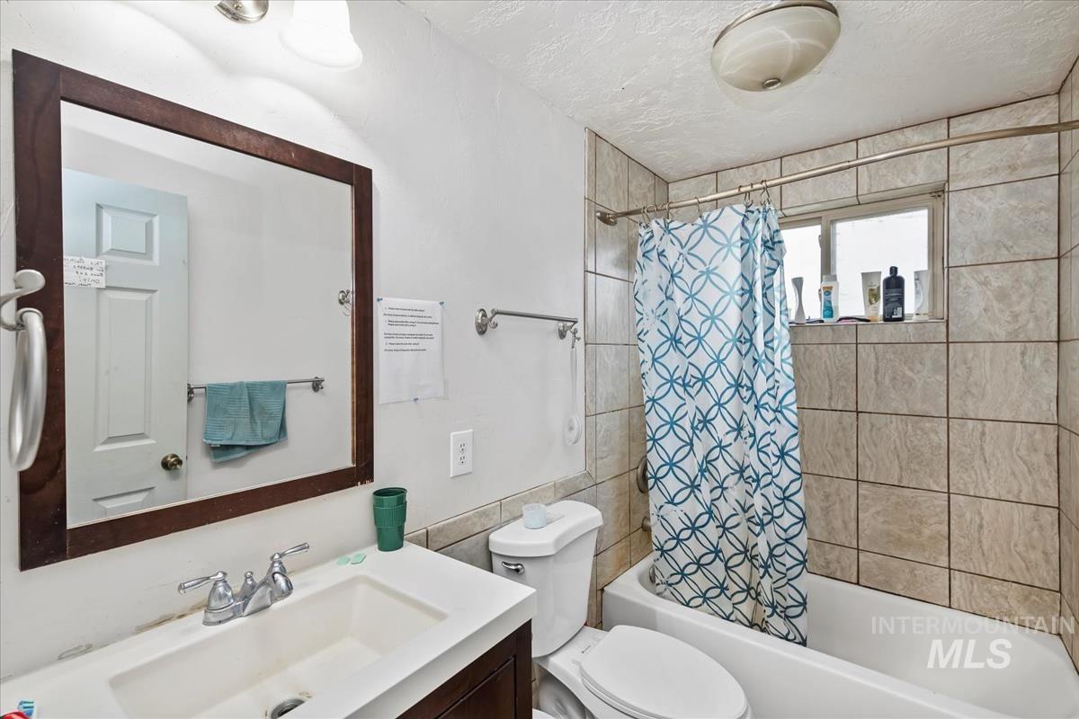 17322 Can-Ada Road Nampa, ID 83687 - Photo 31 of 44 Bathroom featuring vanity, shower / tub combo, a textured ceiling, and tile walls