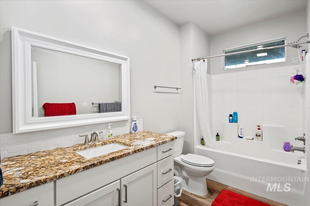 17322 Can-Ada Road Nampa, ID 83687 - Photo 34 of 44 Bathroom featuring shower / tub combo with curtain, vanity, and dark wood finished floors