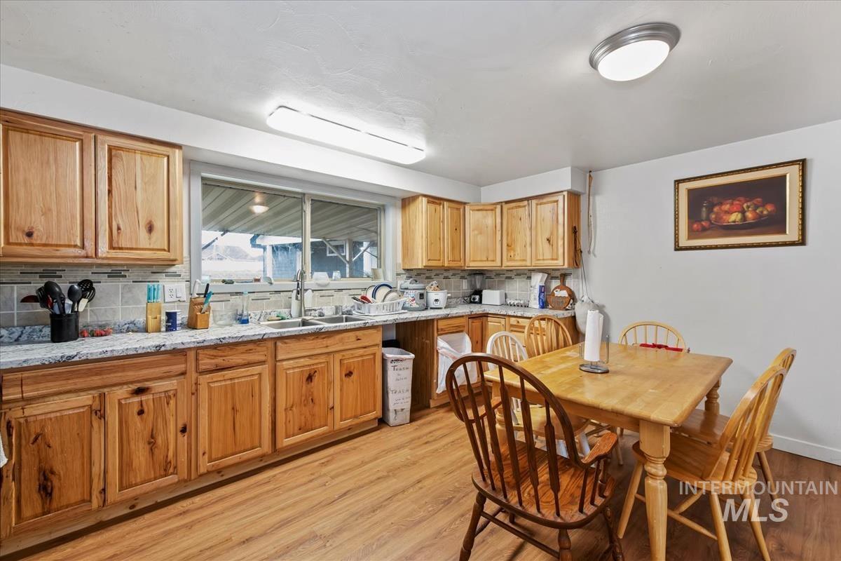 17322 Can-Ada Road Nampa, ID 83687 - Photo 37 of 44 Kitchen with light wood-style flooring, light stone countertops, and backsplash