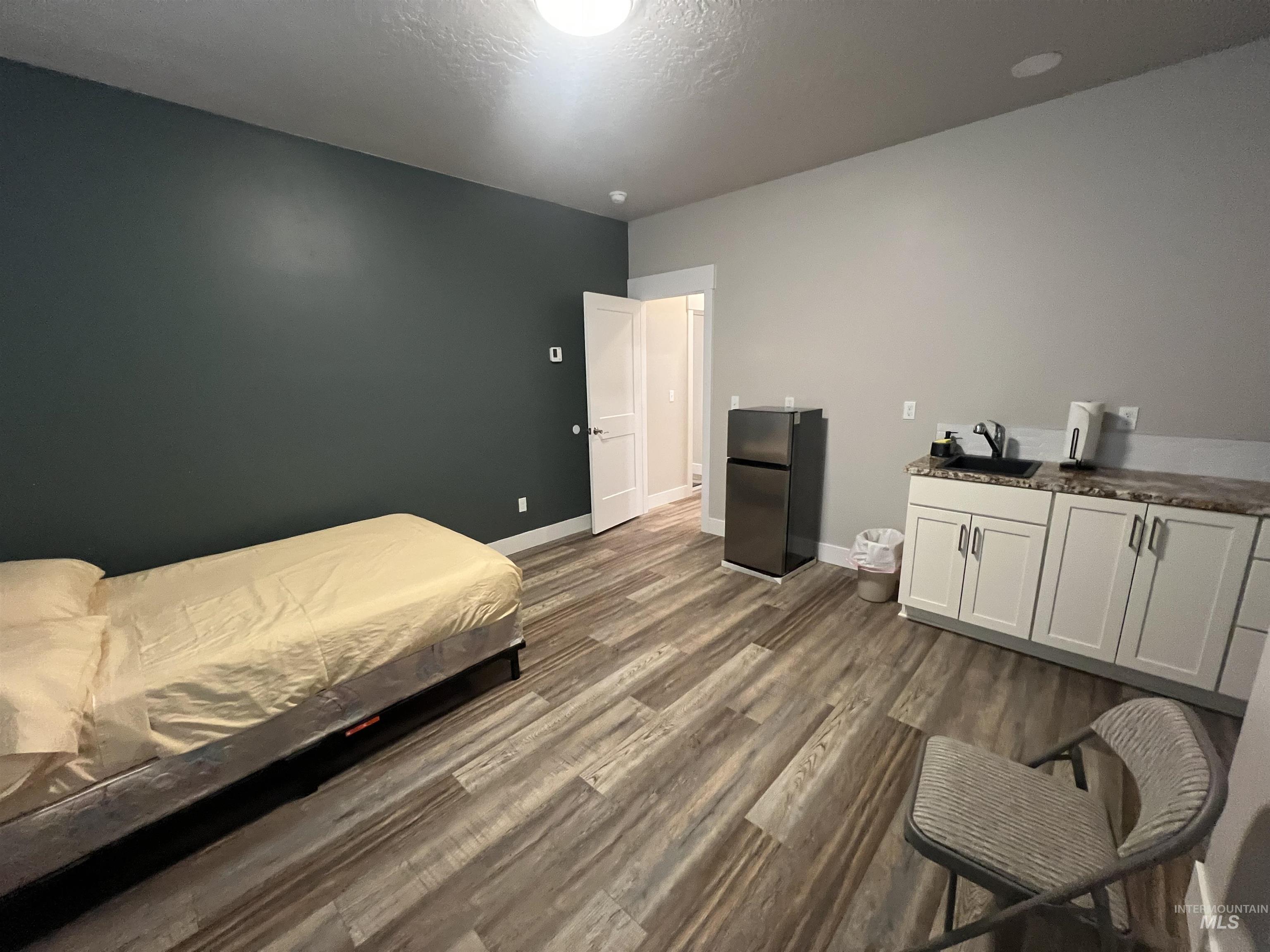 17322 Can-Ada Road Nampa, ID 83687 - Photo 42 of 44 Bedroom with freestanding refrigerator, dark wood-style flooring, and a textured ceiling