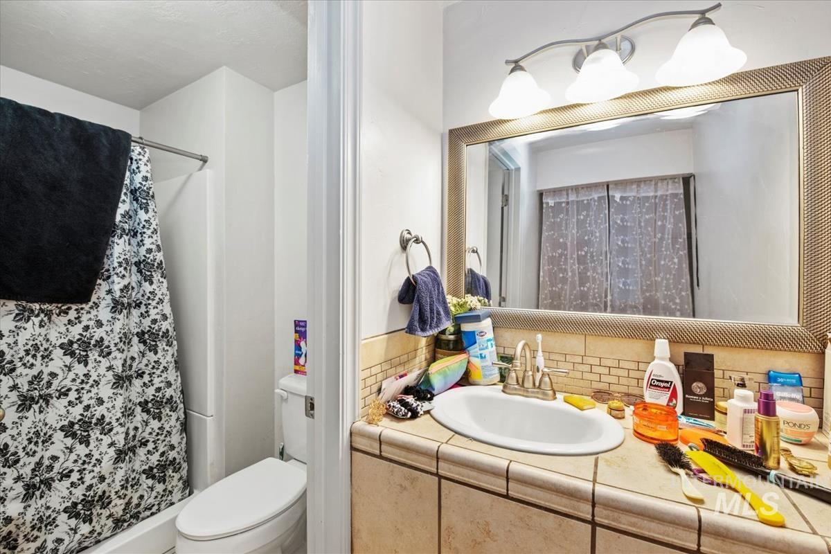 17322 Can-Ada Road Nampa, ID 83687 - Photo 7 of 44 Full bathroom featuring a shower stall, vanity, and tasteful backsplash
