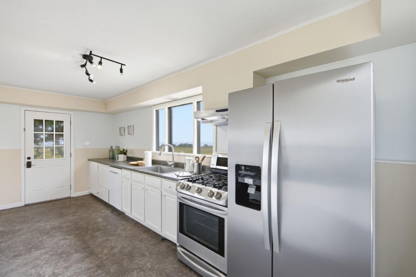 1263 Reservoir Road Pescadero, CA 94060 - Photo 17 of 66 a kitchen with stainless steel appliances and white cabinets