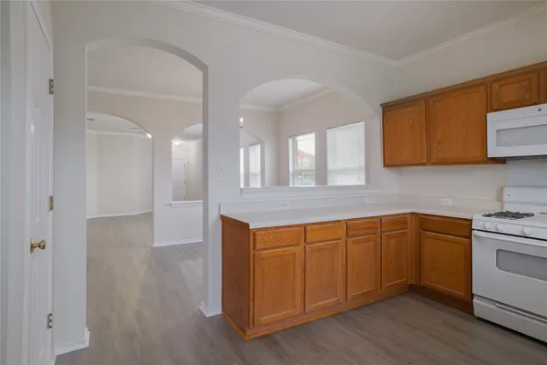 a kitchen with stainless steel appliances granite countertop a sink and cabinets with wooden floor