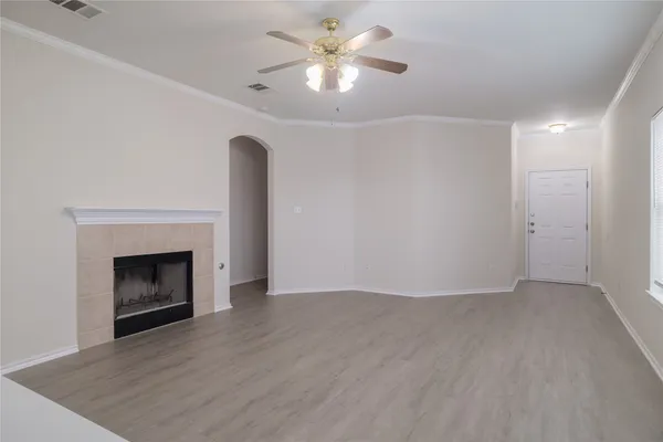 a view of an empty room with window and a fireplace