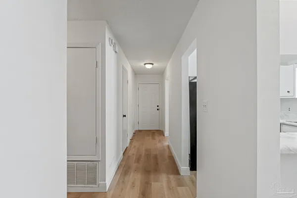 a view of a hallway with wooden floor
