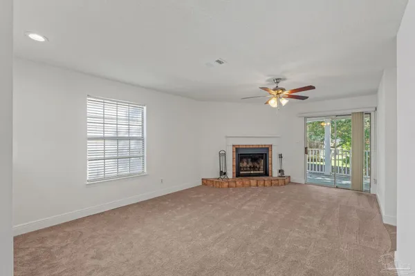 a view of an empty room with a fireplace and a window