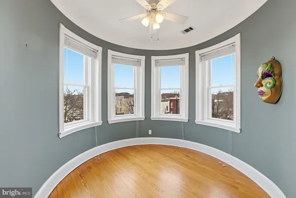 a living room with furniture a bookshelf and a window