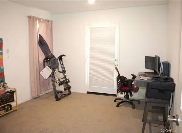 a view of a workspace with furniture and a window