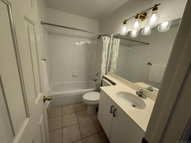 a bathroom with a sink a toilet a mirror a vanity and shower