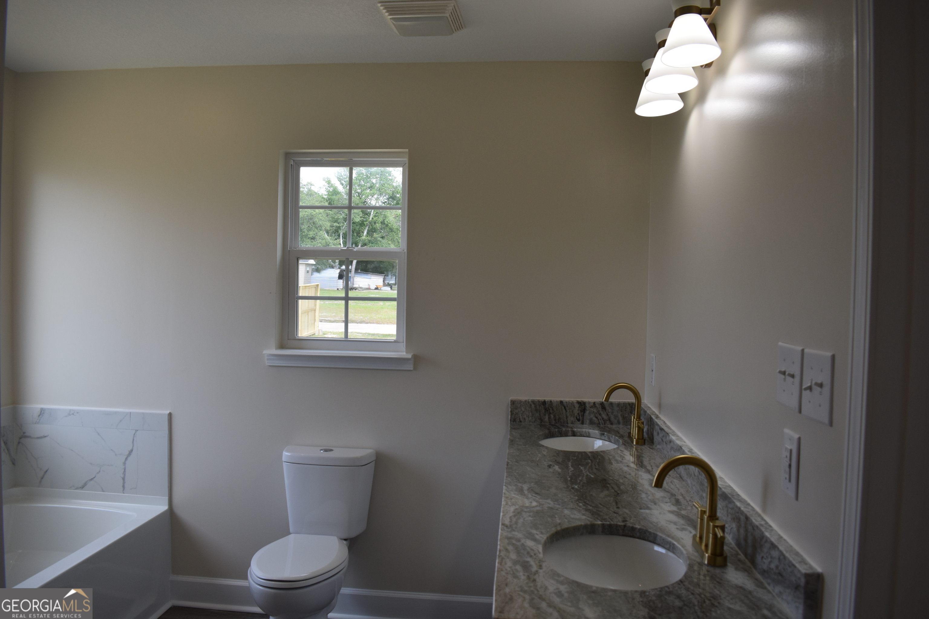 537 Quick Run Road Reidsville, GA 30453 - Photo 11 of 42 a bathroom with a toilet a sink and mirror