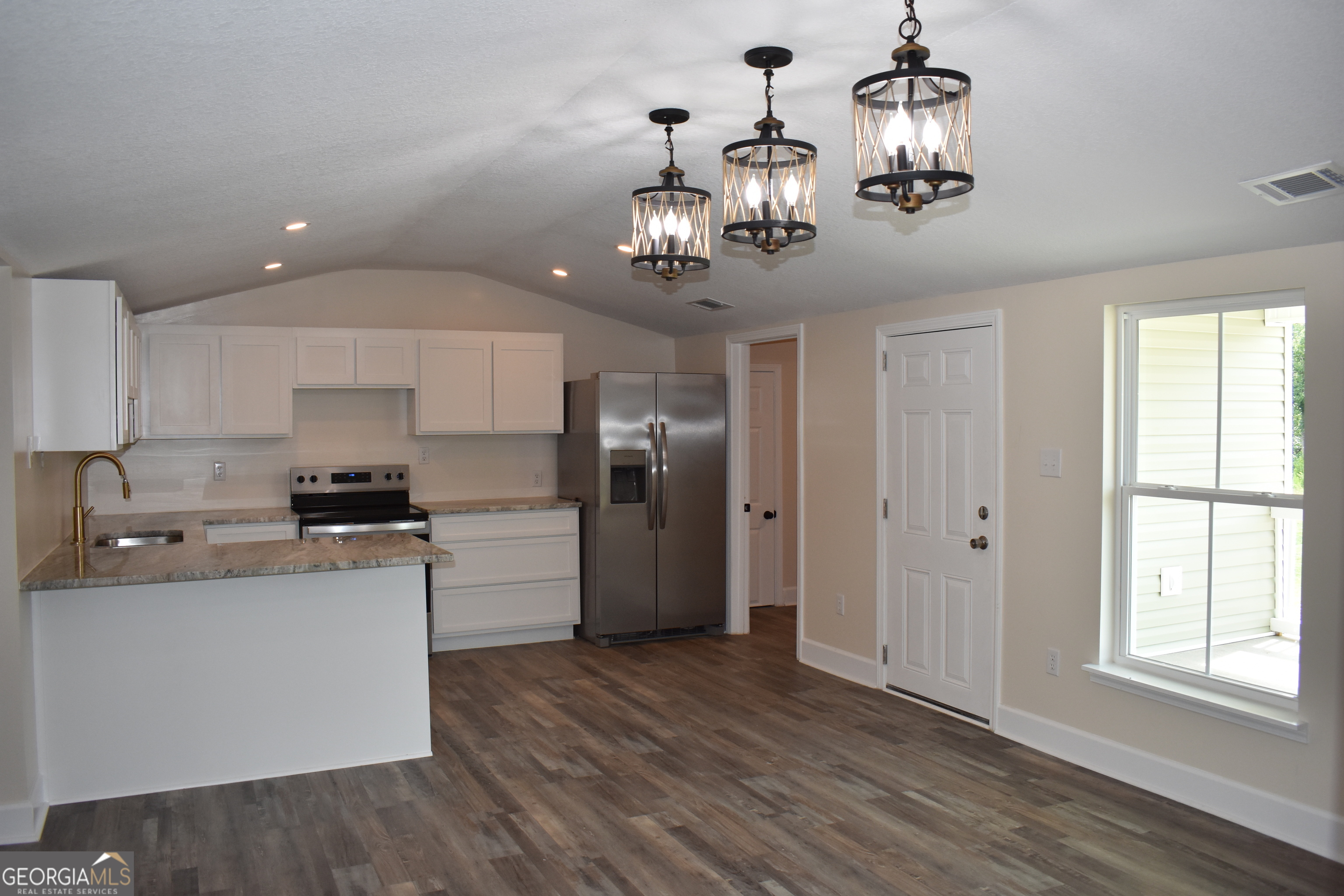 537 Quick Run Road Reidsville, GA 30453 - Photo 9 of 42 a kitchen with a refrigerator chandelier and wooden floor