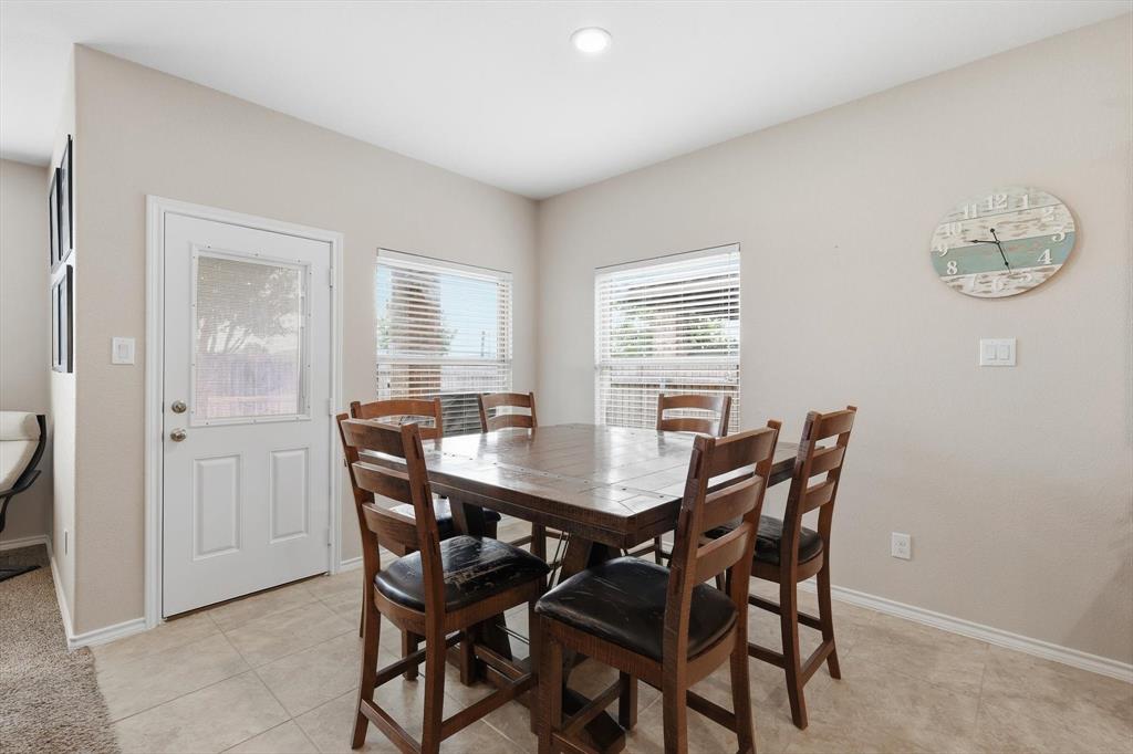 11500 Starlight Ranch Fort Worth, TX 76052 - Photo 18 of 40 Dining area featuring tile flooring, neutral wall colors, and a white door with a glass insert