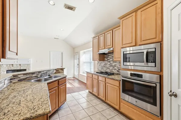 a kitchen with stainless steel appliances granite countertop a stove sink and cabinets