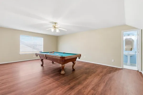 a room with wooden floor a ceiling fan and a window