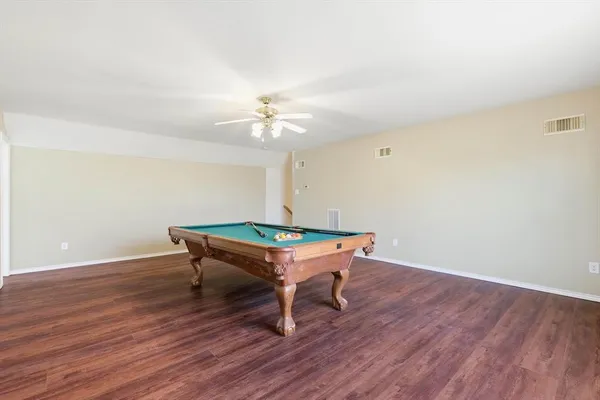 a room with wooden floor and pool table