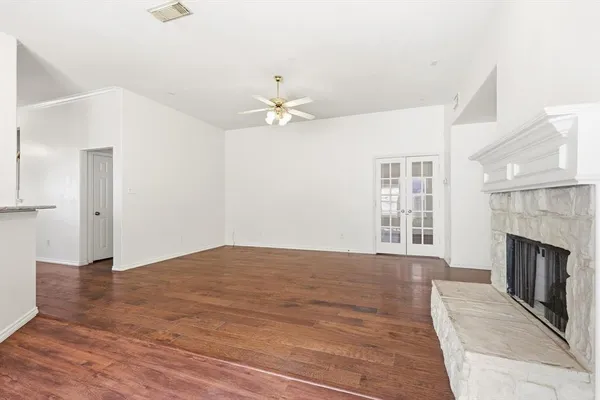 an empty room with windows and a fireplace
