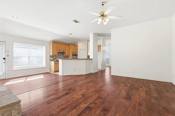 a view of a kitchen with wooden floor and a ceiling fan