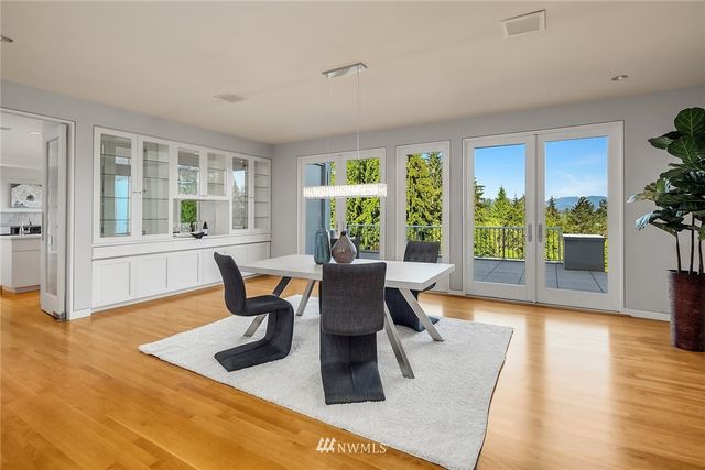 a dining room with wooden floor and windows