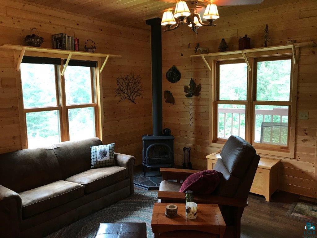 1094 Fernberg Road Ely, MN 55731 - Photo 4 of 12 Living room features a wood stove and laminate flooring.
