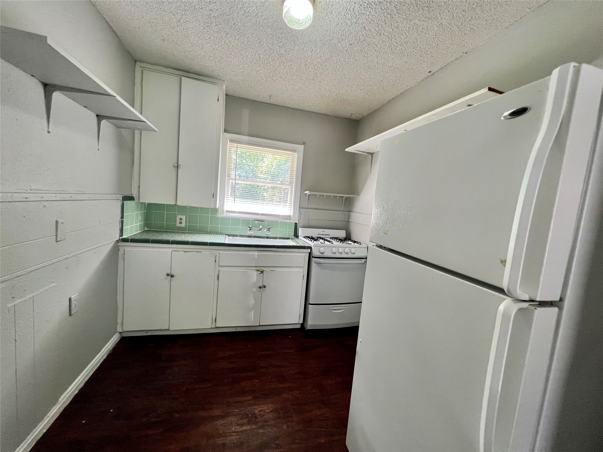 5409 Link Avenue Austin, TX 78751 - Photo 4 of 10 Kitchen featuring white appliances, white cabinetry, dark wood finished floors, open shelves, and a textured ceiling