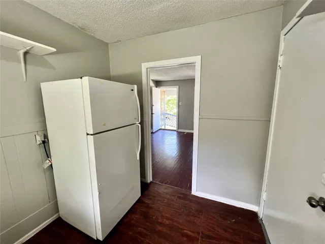 a view of a refrigerator in kitchen and wooden floor