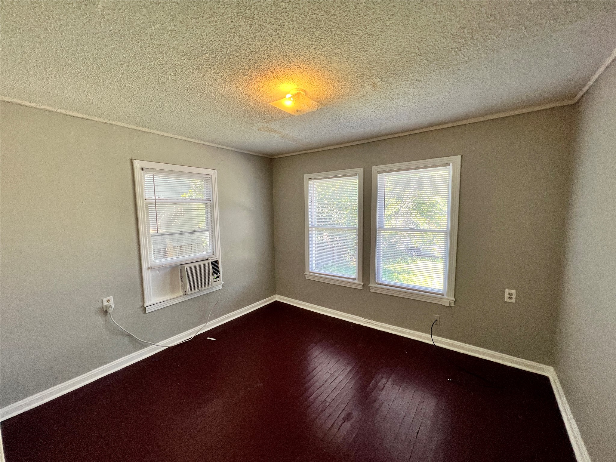 5409 Link Avenue Austin, TX 78751 - Photo 9 of 10 Spare room with hardwood / wood-style flooring, ornamental molding, a textured ceiling, and cooling unit