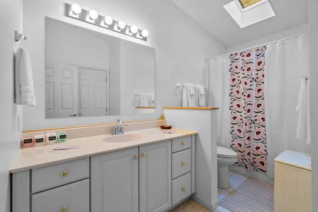 a bathroom with a sink vanity granite and a toilet