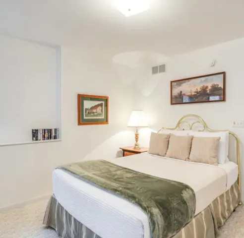 a bedroom with a bed and a wall painting