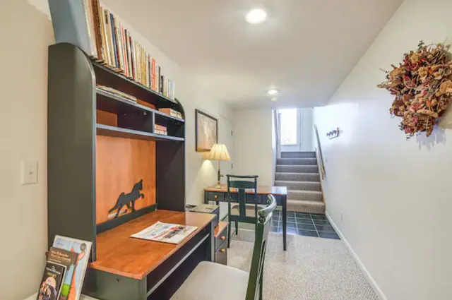 a living room with chairs and a dining table with wooden floor