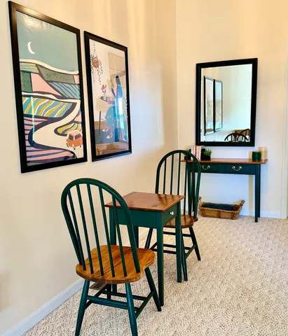 a view of a hallway with chairs and a potted plant
