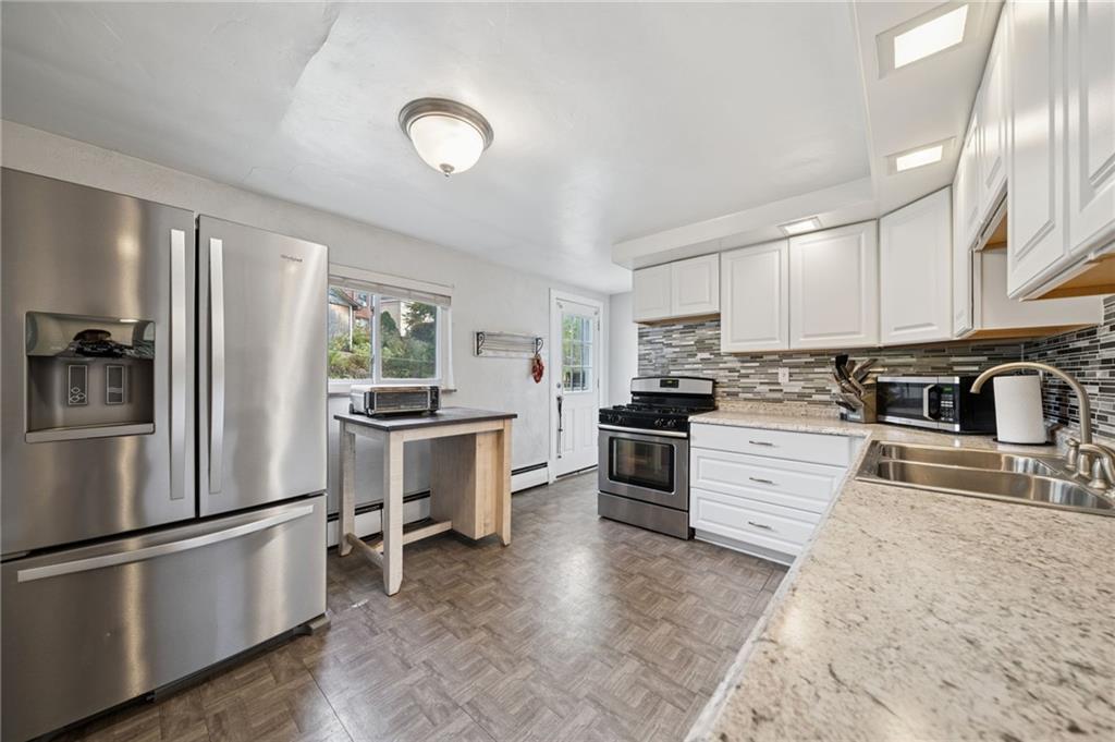 3454 Rigel Street Pittsburgh, PA 15212 - Photo 3 of 37 a kitchen with granite countertop a refrigerator stove top oven and cabinets