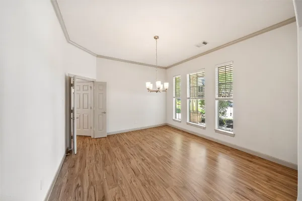 a dining room with furniture a chandelier and wooden floor