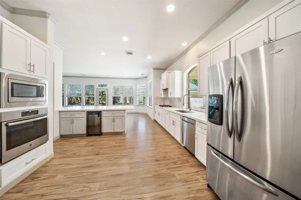 a large kitchen with a large window and stainless steel appliances
