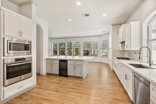 a large kitchen with granite countertop a stove and a sink