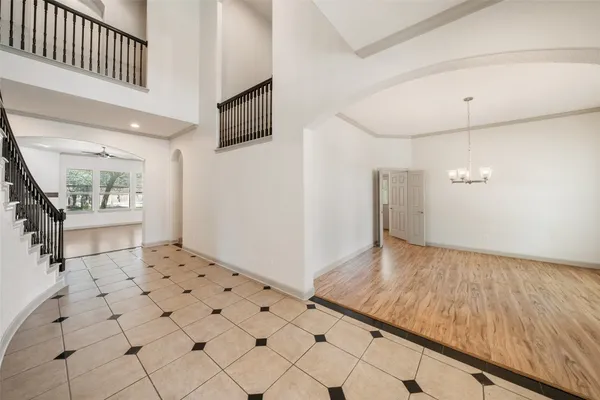 a view of an empty room with wooden floor and a fireplace