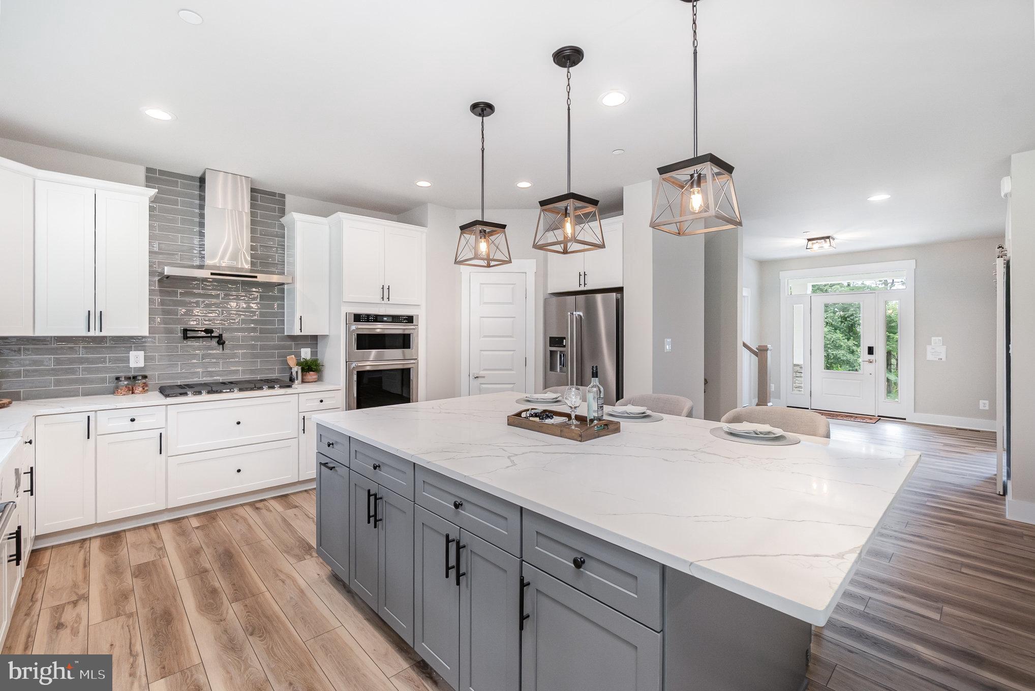 3104 Paper Mill Road Phoenix, MD 21131 - Photo 65 of 77 a large kitchen with kitchen island white cabinets and stainless steel appliances