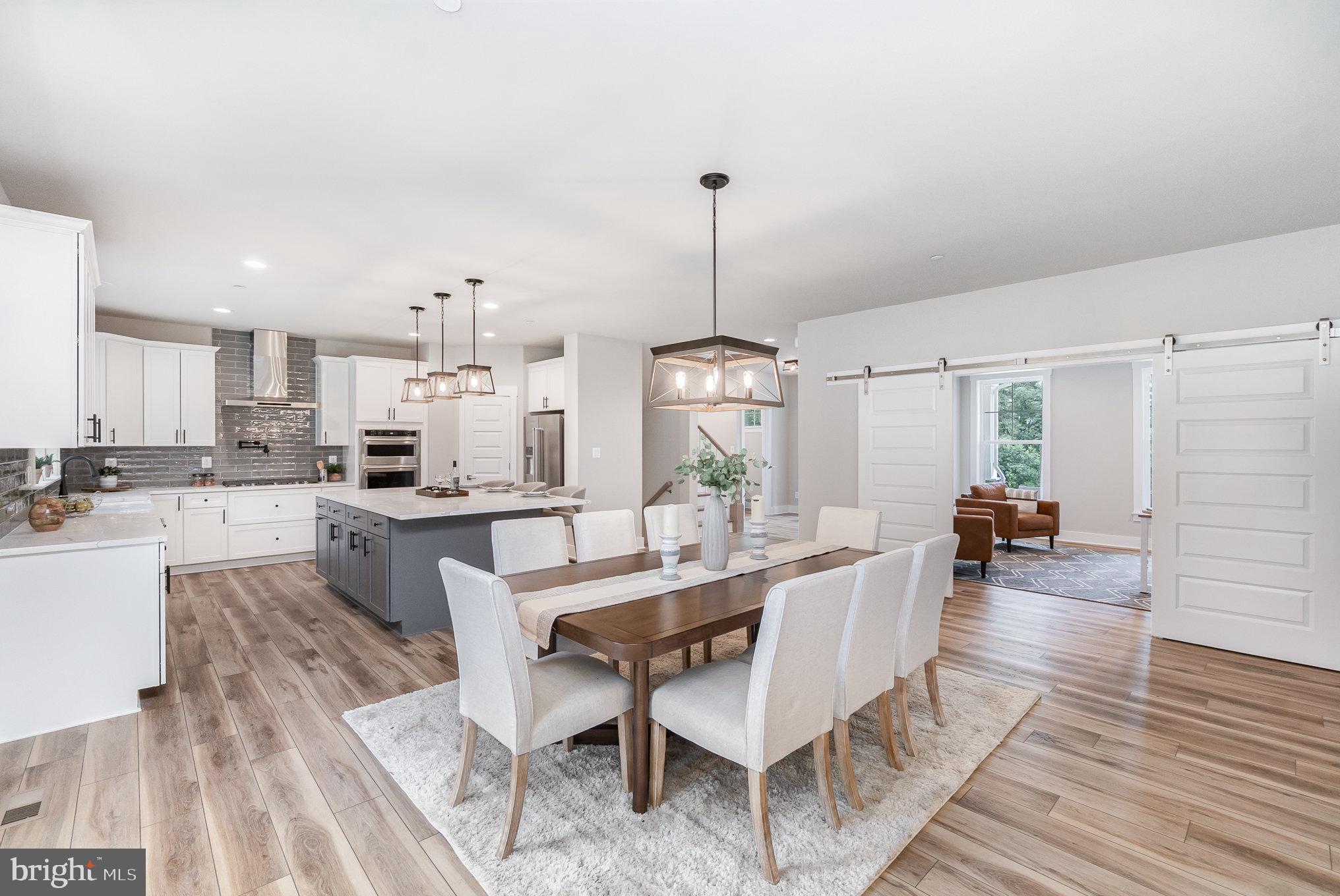 3104 Paper Mill Road Phoenix, MD 21131 - Photo 7 of 77 a view of a dining room and livingroom with furniture wooden floor a chandelier