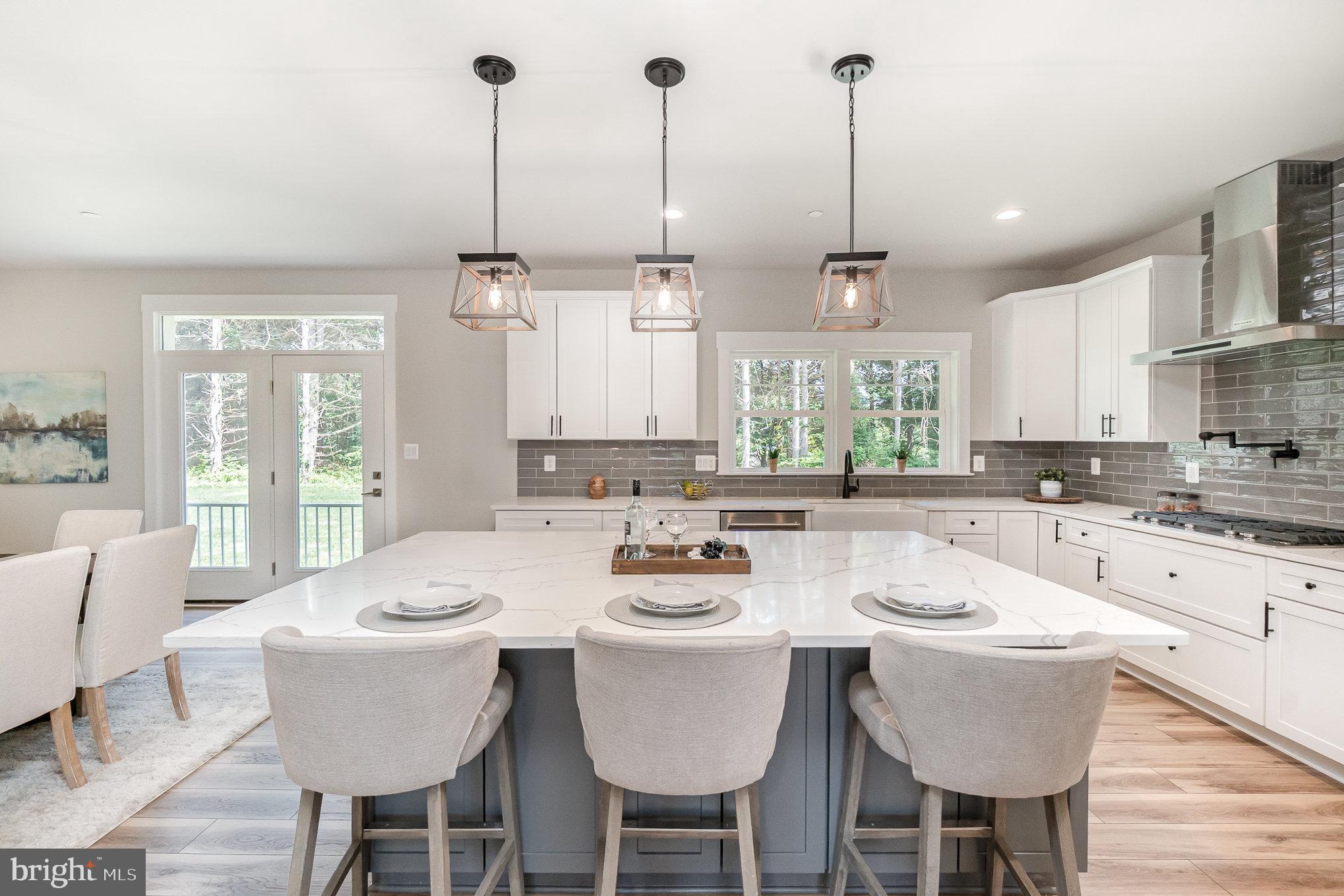 3104 Paper Mill Road Phoenix, MD 21131 - Photo 8 of 77 a kitchen with stainless steel appliances kitchen island granite countertop a dining table chairs and white cabinets