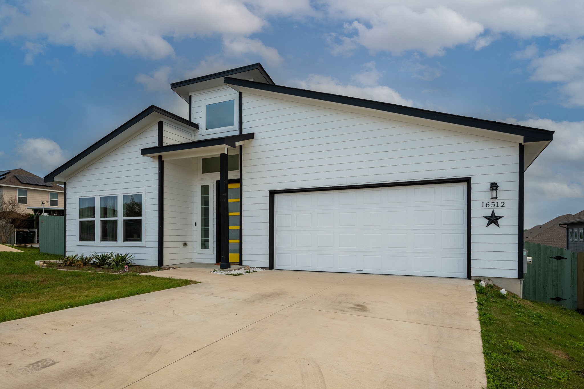 16512 Fetching Avenue Manor, TX 78653 - Photo 4 of 39 View of front of home featuring a garage, concrete driveway, a front lawn, and fence