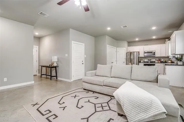 a living room with furniture and kitchen view