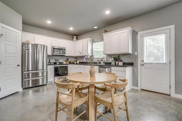 a kitchen with kitchen island a refrigerator stove microwave and cabinets