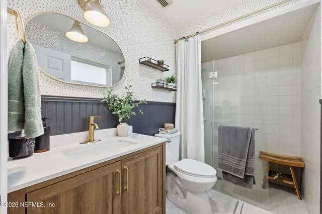 a bathroom with a sink a toilet and shower