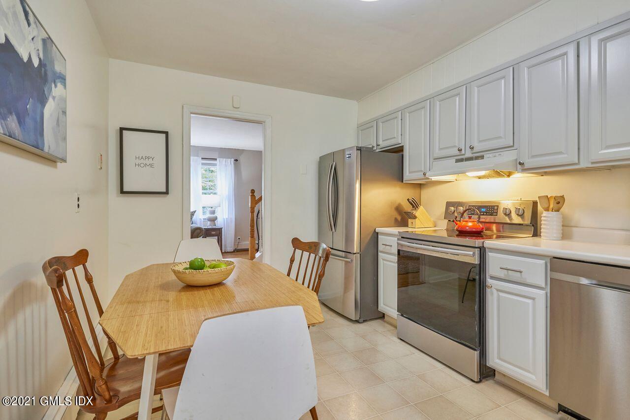16 Cat Rock Road Cos Cob, CT 06807 - Photo 11 of 26 a kitchen with stainless steel appliances granite countertop a dining table and chairs